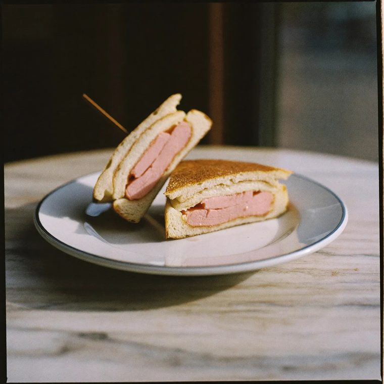 A toasted panini cut in half on a white plate