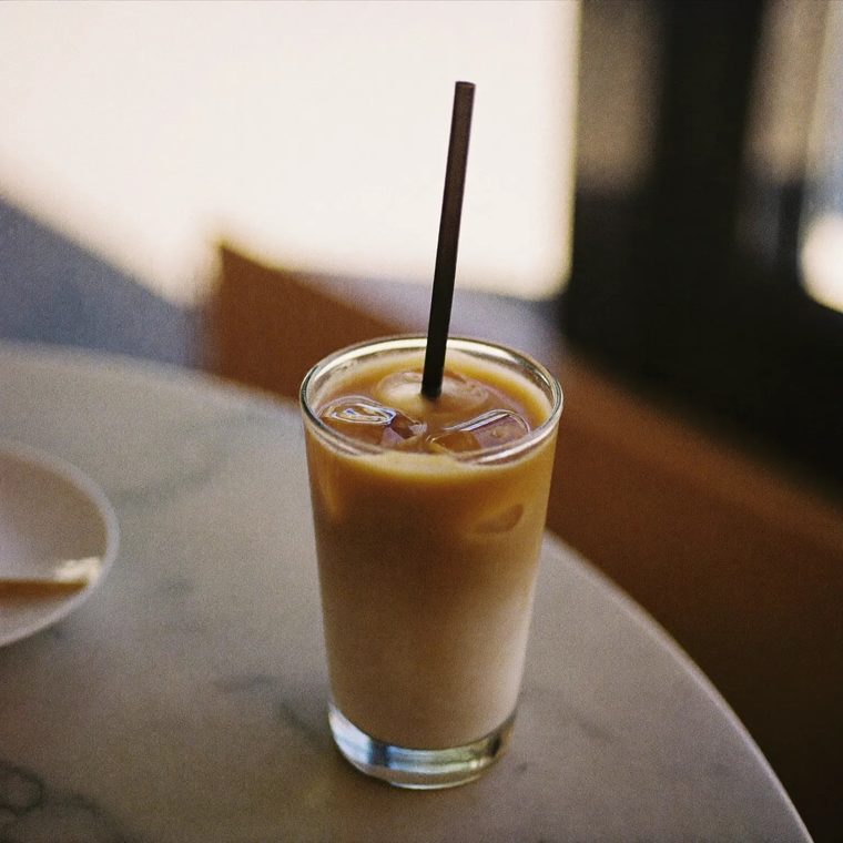 A tall glass of iced coffee on a marble table